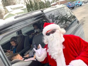 Santa Claus posing with children in the car.